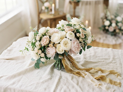 Buket bunga pengantin bernuansa putih dan blush di atas kain linen bertekstur